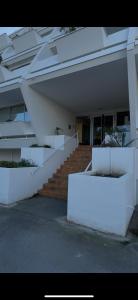 a white building with stairs in front of a building at Les Petits Bateaux-Parking privé-Terrasse in La Grande-Motte
