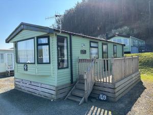 una casita verde en la cima de un campo en Coastal Serenity Escape Clarach Bay Sea Viev Modern 2019 model No Pets, en Aberystwyth