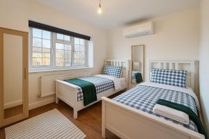 Un dormitorio con dos camas y una ventana en Beautiful 5 bedroom house in central london, en Londres