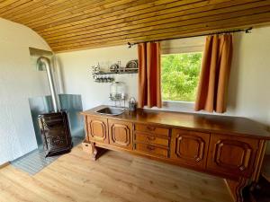 a kitchen with a wooden cabinet and a window at Bauwagen in idyllischer Lage in Schlitz