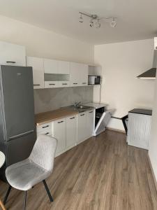 Una cocina con un refrigerador y una silla dentro. en Your Home 14, en Košice 10 fotos más
