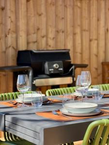 a table with glasses and plates and a piano at Chalet Cimebleu SPA & Sauna in Basse-sur-le-Rupt +48 photos