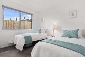 a white room with two beds and a window at The Villa at 165 Contemporary apartment in Warrane +13 photos