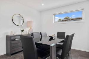 a dining room with a table and chairs and a mirror at The Villa at 165 Contemporary apartment in Warrane