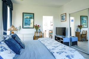 a bedroom with a large bed and a television at Lanai Villas in Koloa