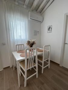 a white dining room with a table and chairs at Casa Peñas 2 in Ronda