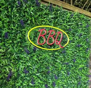 Letrero de Aba en el césped con flores moradas. en Beautiful 5 bedroom house in central london, en Londres