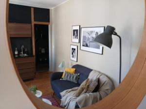 a mirror in a living room with a blue couch at L'Echiquier de Normandie confort cosy et vue premium in Rouen