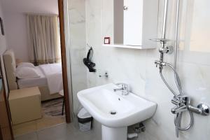 a bathroom with a sink and a phone on the wall at Guesthouse Ijon Berat in Berat