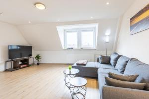 a living room with a couch and a tv at Bahnhof Altstadt Stilvolles 85 qm Apartment mit Smart-TV in Osnabrück