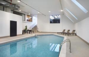 a swimming pool with chairs and a table in a building at AC Hotel Frisco Colorado in Frisco