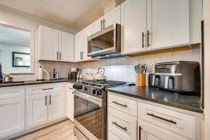アトランタにあるNear GICC and ATL Airport Modern Townhome!の白いキャビネットとステンレス製の電化製品を備えたキッチン