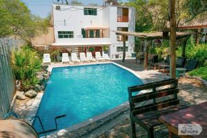 a pool with chairs and a house in the background at Rochabus in Ica