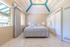 ein Schlafzimmer mit einem Bett in einem Zimmer mit einer Decke in der Unterkunft Relaxing & Modern House - Walking Distance from Historic Center of Paraty in Paraty