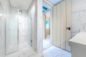 ein weißes Bad mit einer Dusche und einer Glastür in der Unterkunft Relaxing & Modern House - Walking Distance from Historic Center of Paraty in Paraty + 21 Fotos