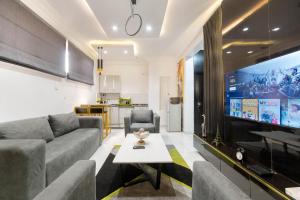 a living room with a couch and a large tv at 2 bedroom Luxury Shortlet Apartment in Osapa London, Lekki in Lagos +11 photos