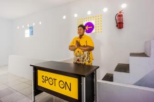 un homme debout à côté d'un panneau sur une table dans l'établissement OYO 2277 Lulu Homes, à Makassar