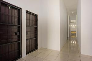 - un couloir avec deux portes et du carrelage dans l'établissement OYO 2277 Lulu Homes, à Makassar