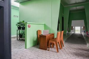 班达楠榜OYO 93695 Guest House Riharti Syariah的客房配有书桌、椅子和笔记本电脑