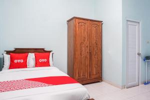 班达楠榜OYO 93695 Guest House Riharti Syariah的带床和木柜的卧室 更多23张照片