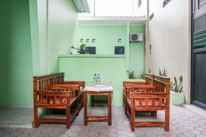 班达楠榜OYO 93695 Guest House Riharti Syariah的一组木椅和一张桌子