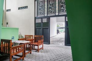 班达楠榜OYO 93695 Guest House Riharti Syariah的配有木椅、桌子和门的房间