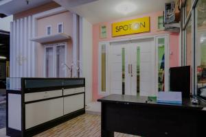 an office with a desk and a sign on the wall at OYO 2417 Melati Residence in Blitar +48 photos