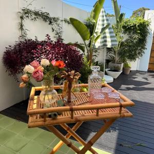 un tavolo in legno con vasi e fiori su un patio di Studio 34 - Nelson Bay a Nelson Bay