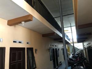 a room with motorcycles parked in a building with a staircase at Hotel O Homestay Puri Indah SyariahNearBandara Internasional Juanda in Betro +11 photos