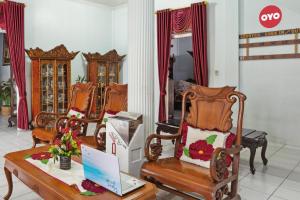 a room with three chairs and a laptop on a table at OYO Life 92803 Penginapan Purnama in Kayuagung