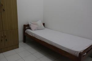 a bedroom with a bed with a pillow on it at OYO Life 93786 Kost Alamku Syariah in Limbengan