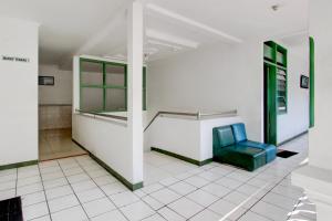 a waiting room with a blue chair in a building at Hotel O Gurita in Solo