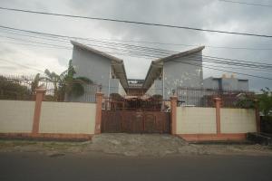 a house behind a fence with a gate at Hotel O Wisma Bunda Syariah Near Man Pinrang in Salo