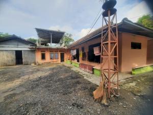 a house with a broom on the side of it at Hotel O Home Stay Syariah Habibie in Sukabumi +15 photos