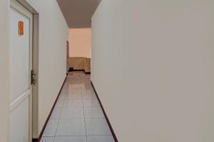 an empty hallway with a door and a tile floor at OYO Life 92546 Kost Merah Bojongsoang Syariah in Bandung