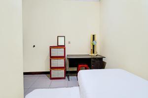 a bedroom with a desk and a bed and a table at OYO Life 92546 Kost Merah Bojongsoang Syariah in Bandung