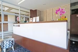 a lobby with a reception counter and a chair at Capital O 1898 Louise Place in Tjiandjur +25 photos