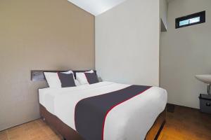 a bedroom with a large white bed with pillows at Capital O 1898 Louise Place in Cianjur