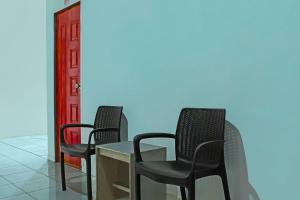 3 sillas y una mesa en una sala de espera en Hotel O Wilma Kost Syariah, en Banjarmasin