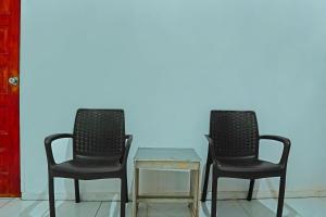 dos sillas y una mesa frente a una pared en Hotel O Wilma Kost Syariah, en Banjarmasin 20 fotos más