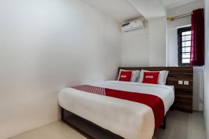 a bedroom with a large bed with red pillows at Capital O 3463 Cimahi Guest House in Bandung