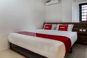 a bedroom with a large bed with two red pillows at Capital O 3463 Cimahi Guest House in Bandung