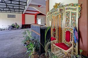 ein Raum mit einem Stuhl neben einem Gebäude in der Unterkunft OYO Life 91480 Putridapisa Syariah in Sumedang + 22 Fotos