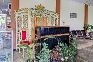 einen großen Thron in einem Raum mit Pflanzen in der Unterkunft OYO Life 91480 Putridapisa Syariah in Sumedang