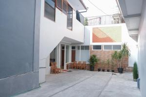 a white building with chairs and tables in a courtyard at Hotel O 111 Residence in Batu