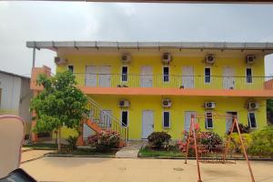 a yellow building with a balcony on the side at Hotel O Garuda Bandara Guesthouse in Palembang