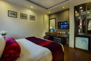 ein Hotelzimmer mit einem Bett und einem TV in der Unterkunft Golden Art Hotel in Hanoi