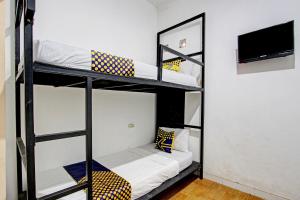 a room with three bunk beds and a television at Hotel O Cindelaras B&b Bunk Bed in Piyungan