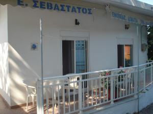 - un bâtiment blanc avec 2 chaises sur un balcon dans l'établissement Filio Sevastatou Rooms, à Therma