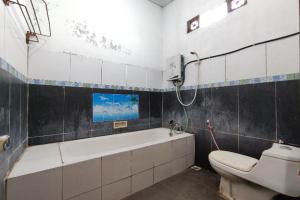 a bathroom with a bath tub and a toilet at SPOT ON 91105 Hotel Salsabila in Magelang +6 photos